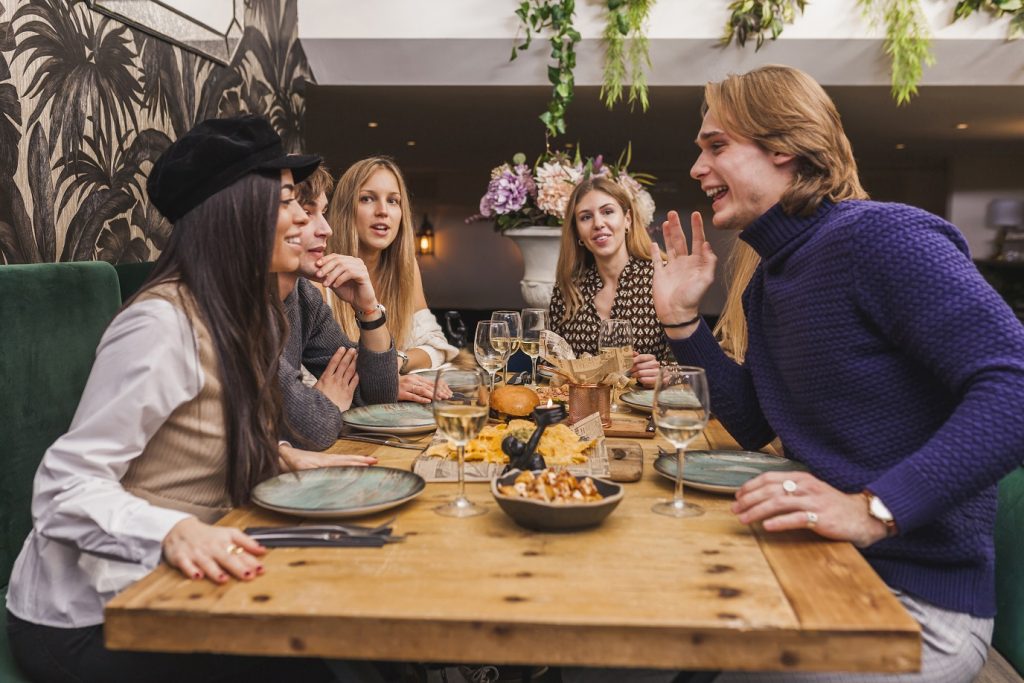 Group of caucasian friends enjoying themselves at a dinner party at restaurant